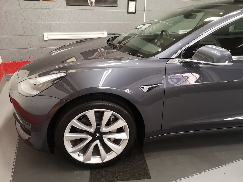 Bonnet and front wing view of a detailed Tesla Model 3 in metallic grey.