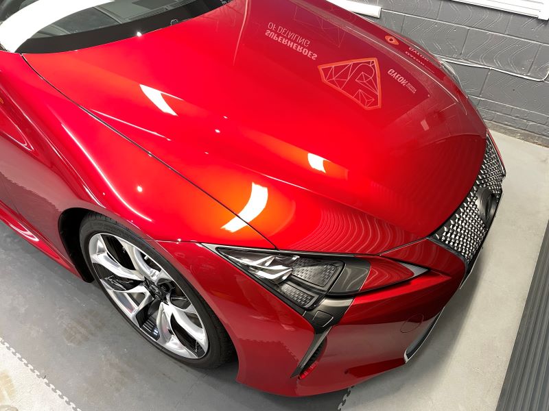 Lexus LC bonnet in metallic red after receiving a machine polish 