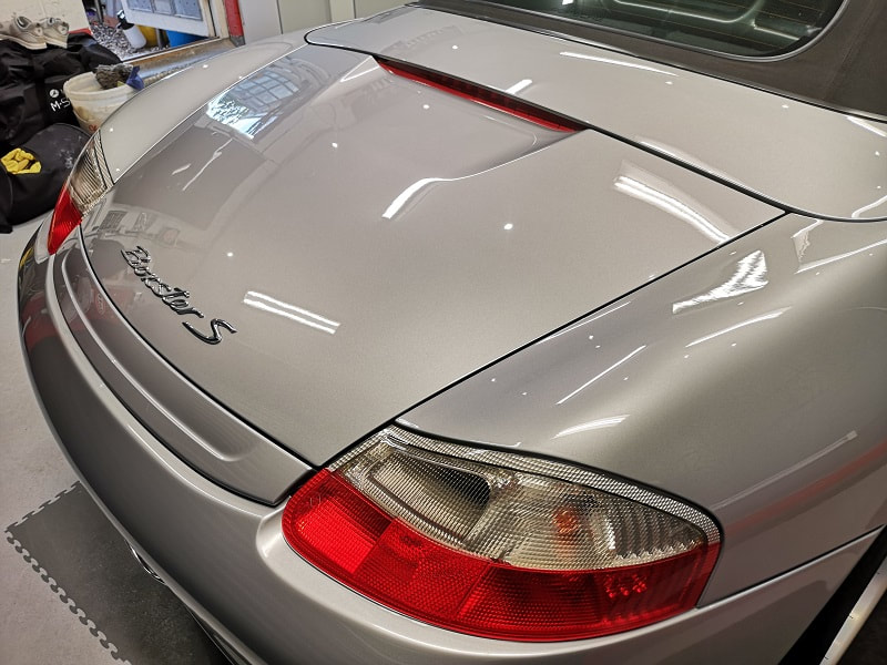 Glossy boot lid of a Porsche Boxster in silver. 